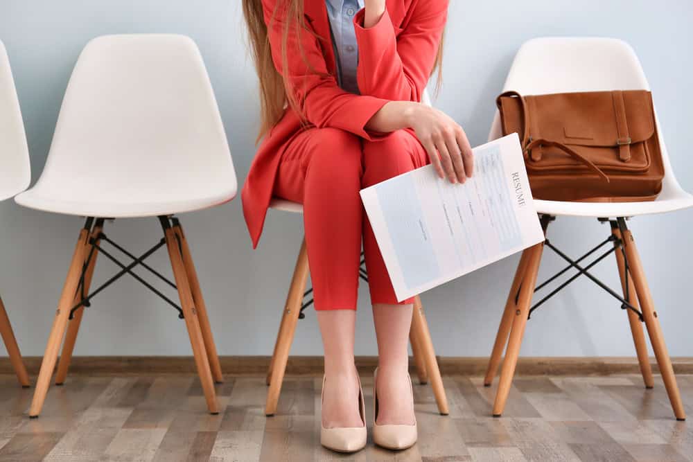 Professional woman holding resume at Brooklyn Resume Studio, job interview preparation, career coaching, professional resume services.